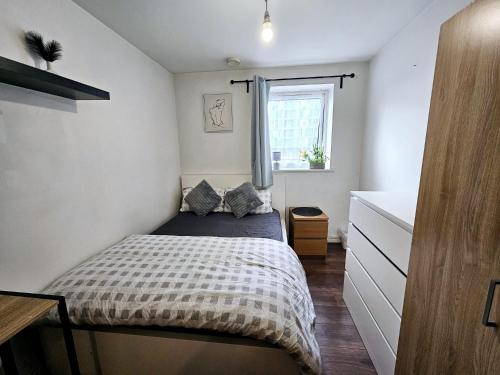 ein kleines Schlafzimmer mit einem Bett und einem Fenster in der Unterkunft Stratford views in London