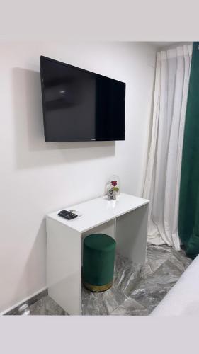 Habitación con escritorio blanco y TV en la pared. en Domus Leone, en Nápoles
