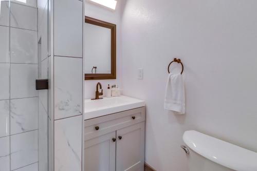 a white bathroom with a sink and a mirror at OB Loungin 2 in San Diego