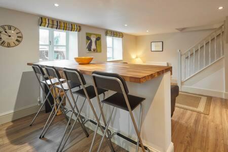 a kitchen with a bar with stools and a clock at Host & Stay - Himmell in Consett