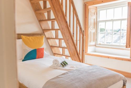 um quarto com uma cama e uma escada de madeira em Central Kendal Georgian Home with private courtyard & free parking em Kendal