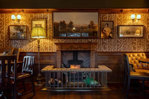 a room with a fireplace and a table and chairs at Bedford Arms Hotel in Rickmansworth