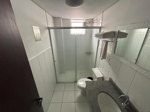 a bathroom with a toilet and a sink and a shower at Hotel Pax in Ponta Grossa