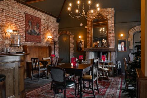 a restaurant with tables and chairs and a mirror at Bedford Arms Hotel in Rickmansworth