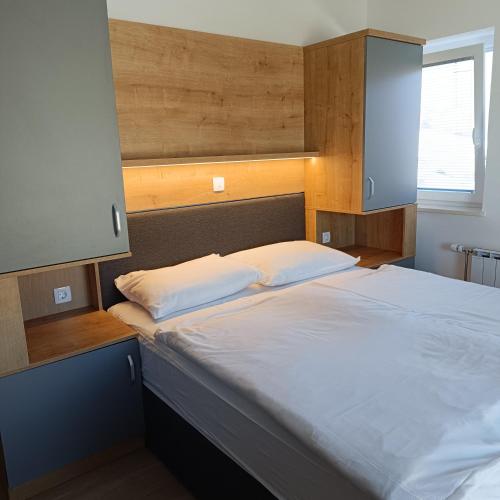 a bedroom with a large bed with white sheets at Guesthouse Haler in Podčetrtek