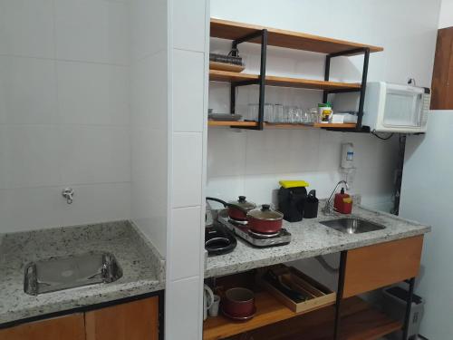 una piccola cucina con bancone e lavandino di Condomínio da Fé - Studio Loft - 12º andar a Cachoeira Paulista