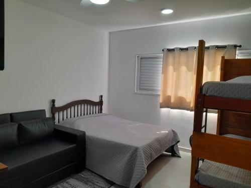 una camera con letto, divano e sedia di Condomínio da Fé - Studio Loft - 12º andar a Cachoeira Paulista