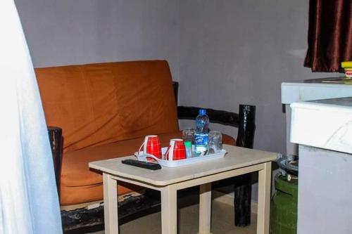 una mesa pequeña con bebidas junto a una silla en Mtwapa Empire holiday Apartments, en Mtwapa