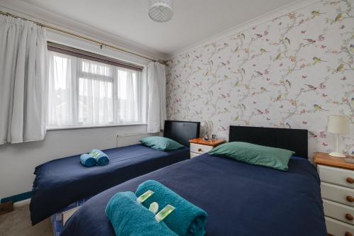 een slaapkamer met 2 bedden en een raam bij Coastal Haven in Felpham