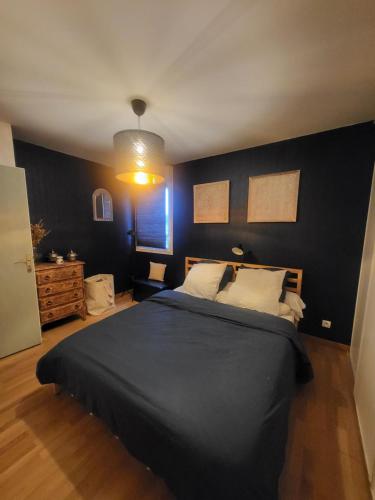 une chambre avec un grand lit avec un mur noir dans l'établissement Appartement en Location pour les Jeux Olympiques, à Deuil-la-Barre