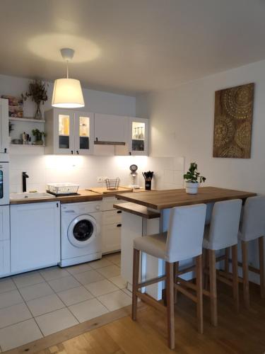 une cuisine avec une table en bois et des appareils électroménagers blancs dans l'établissement Appartement en Location pour les Jeux Olympiques, à Deuil-la-Barre