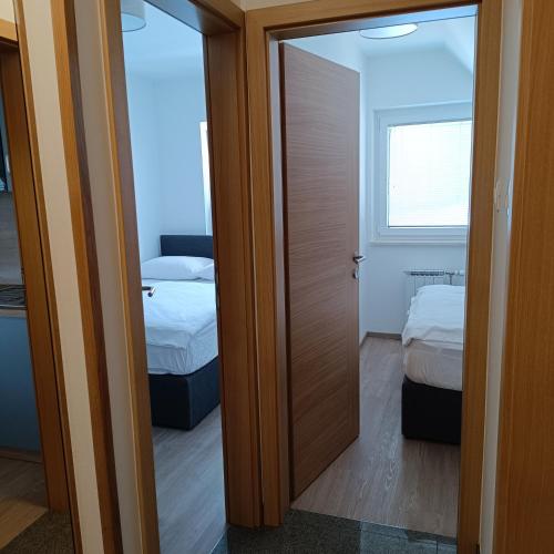 a door leading to a bedroom with two beds at Guesthouse Haler in Podčetrtek