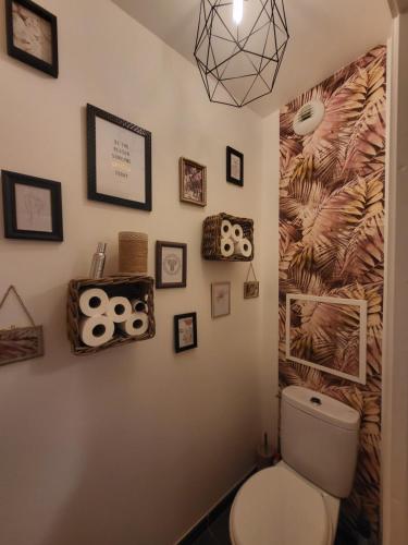 La salle de bains est pourvue de toilettes et de photos murales. dans l'établissement Appartement en Location pour les Jeux Olympiques, à Deuil-la-Barre