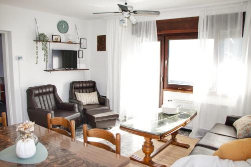 ein Wohnzimmer mit einem Sofa, einem Tisch und Stühlen in der Unterkunft Pod brejgon in Kuzma