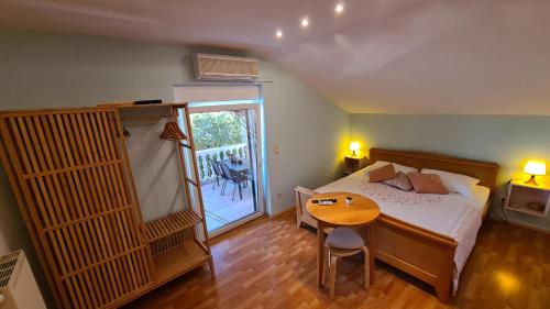 1 dormitorio con cama, mesa y puerta en Ocean View Apartments, en Bilice