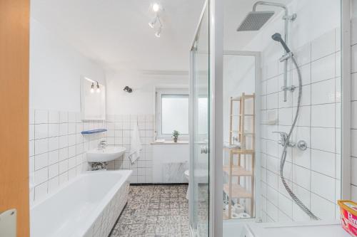 Baño blanco con bañera y lavamanos en MONTEURWOHNUNG Gingen an der Fils RAUMSCHMIDE Apartments, 