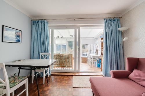 a living room with a table and a couch at Coastal Haven in Felpham