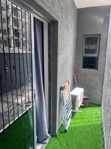 uma varanda aberta com relva verde no chão em City View Apartments em Lekki