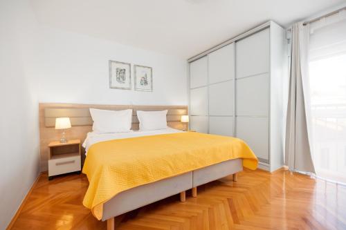 a bedroom with a large bed with a yellow blanket at Apartment Mares in Split
