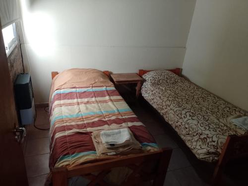 a small bedroom with a bed in a room at Departamentos Haiti in Bahía Blanca