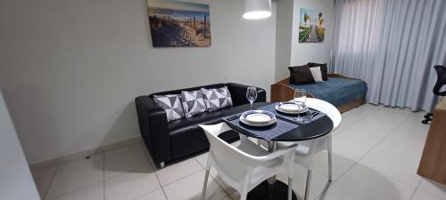 uma sala de estar com uma mesa e um sofá em Flat Sorriso - Beach Class Conventions no Recife