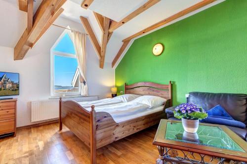 a bedroom with a green wall with a bed and a table at Dia Mare, EG West in Ueckeritz