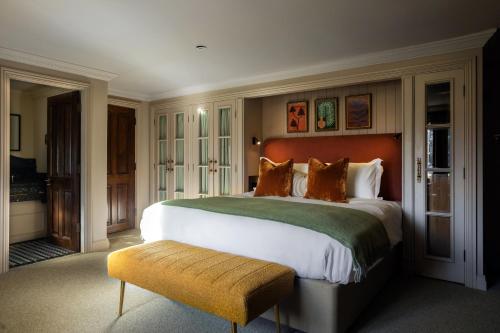 a large bedroom with a large bed and a bench at Bedford Arms Hotel in Rickmansworth