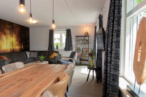 a living room with a table and a couch at Beekje - Rolstoelvriendelijk en comfortabel 8p in Otterlo