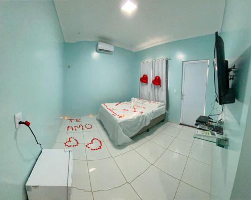 a room with a bed and a tv in it at Suites Recanto da Sarah in Flecheiras