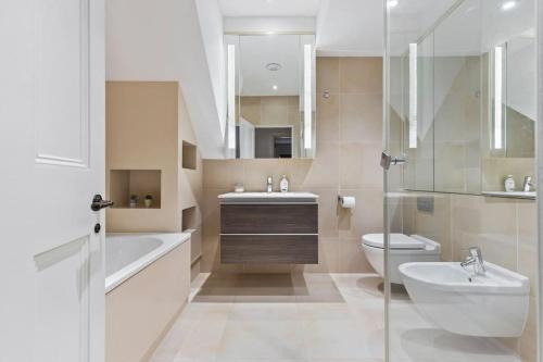 a bathroom with a sink and a toilet and a tub and sink at Luxury 3 Bed Flat in Kensington in London