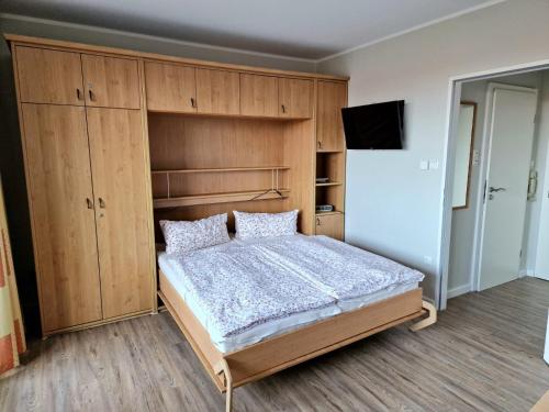 um quarto com uma cama e armários de madeira em Tief 10 Wattwurm em Wangerland