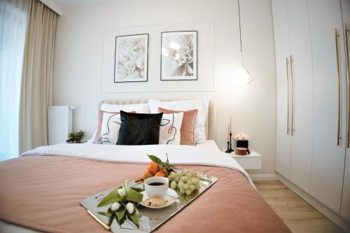 a tray of fruit on a bed in a bedroom at Gea Eco Appartment 200m von Ostsee WiFi mit incl Parkplatz in Sianozety