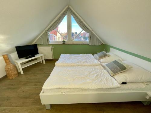 ein Schlafzimmer mit einem Bett und einem TV. in der Unterkunft Wattvogel in Greetsiel
