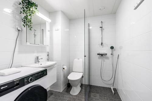 a white bathroom with a toilet and a shower at SPOT Apartments Hämeenlinna in Hämeenlinna