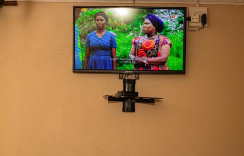a flat screen tv hanging on a wall at Lizpeter guest house in Elim