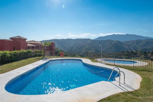 a swimming pool with mountains in the background at Apartment Balcones del Lago in Istán