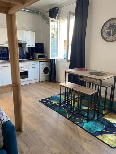 a kitchen with a table and two stools at Studio paisible à Lorient ! in Lorient