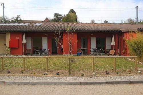 a red house with tables and chairs in front of it at appartement confort 5 personnes in Grandson