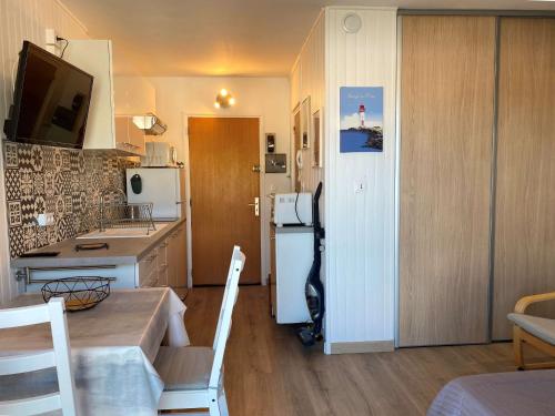 une petite cuisine avec une table et un réfrigérateur dans l'établissement Studio rénové avec balcon, proche parc, WiFi, lave-linge, Balaruc-les-Bains - FR-1-553-233, à Balaruc-les-Bains