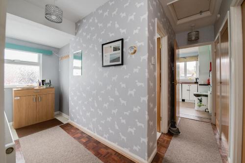 a hallway with a white wall with a picture on it at Coastal Haven in Felpham