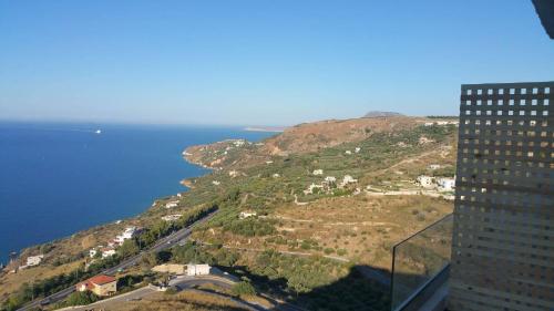 a view of a hill with the ocean and a building at PALACE Sea view in Megála Khoráfia