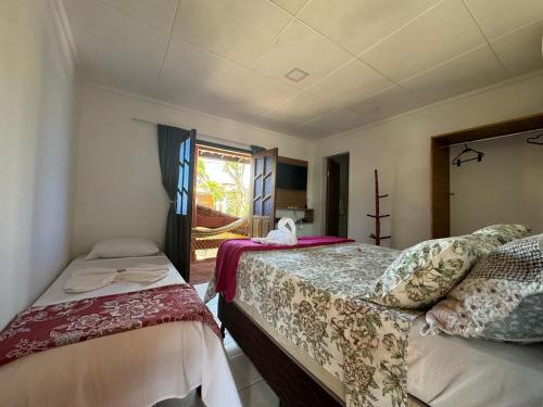 een slaapkamer met 2 bedden en een raam bij Pousada da Barra in Barra Grande