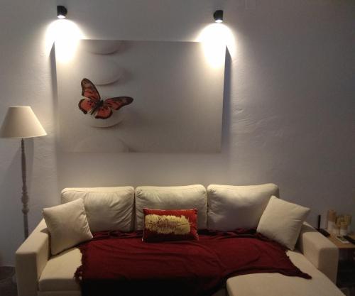 a living room with a couch with a butterfly on the wall at PALACE Sea view in Megála Khoráfia