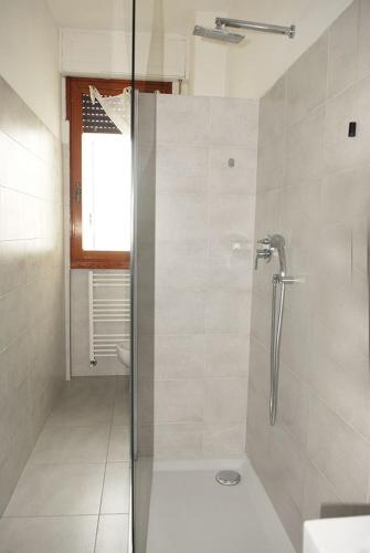 uma casa de banho com um chuveiro e uma porta de vidro em Viareggio Seaside Apartment em Viareggio