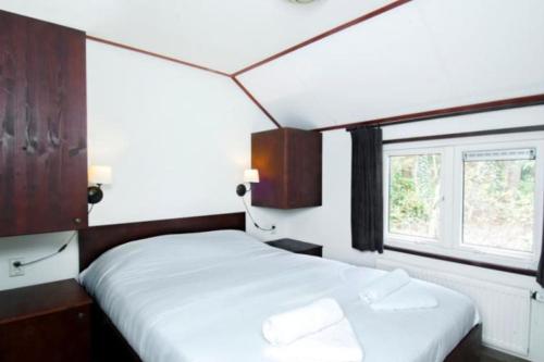 a bedroom with two beds and a window at Korhoen - 6p HeideBungalow met bedstee in Otterlo