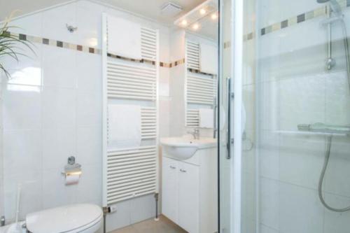 uma casa de banho com um WC, um lavatório e um chuveiro em Korhoen - 6p HeideBungalow met bedstee em Otterlo