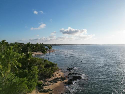 uma vista para uma praia com palmeiras e para o oceano em Pousada da Barra em Barra Grande