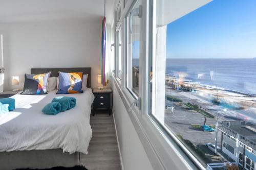a bedroom with a bed with a view of the ocean at 19 Undercliffe in Felixstowe