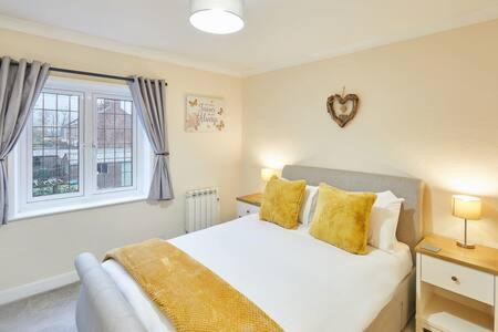 Un dormitorio con una cama con almohadas amarillas y una ventana en Host & Stay - Jackson Cottage en Thirsk