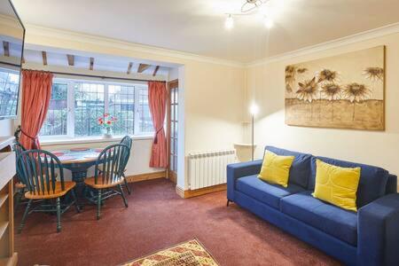 a living room with a blue couch and a table at Host & Stay - Jackson Cottage in Thirsk